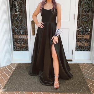 Beautiful black prom dress with slit on leg and laced up back. Also has pockets